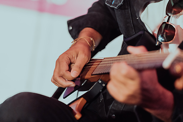 Image showing Practicing in playing guitar. Handsome young men playing guitar