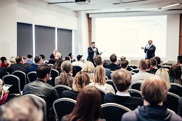 Image showing I have a question. Group of business people sitting in conference hall. Businessman raising his arm. Conference and Presentation. Business and Entrepreneurship