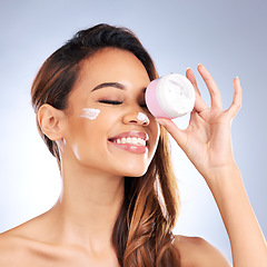 Image showing Cream, jar and beauty of happy woman in studio with facial cosmetics product on grey background. Female model, face lotion and skincare container for sunscreen, aesthetic dermatology and moisturizer