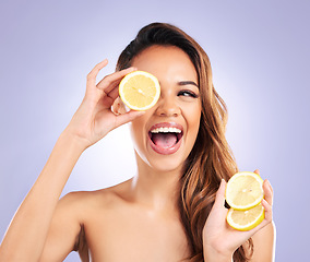Image showing Vitamin c, lemon and eye of woman with detox, natural or organic beauty isolated in a purple studio background. Excited, happy and young female person with vitamin c for healthy skincare or wellness
