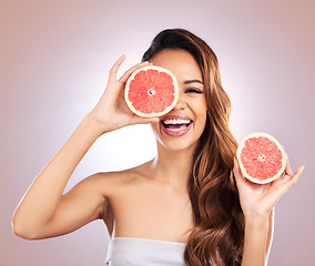 Image showing Vitamin c, grapefruit and portrait of woman with healthy, natural or organic beauty isolated in a brown studio background. Excited, happy and young female person with citrus for skincare or detox