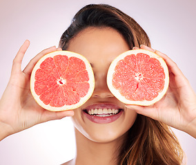 Image showing Beauty, grapefruit and eyes of woman with healthy, natural or organic care isolated in a brown studio background. Citrus, happy and young female person with vitamin c for skincare, wellness or detox