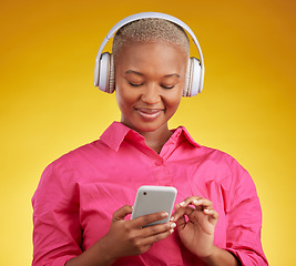 Image showing Phone, smile and black woman with music headphones in studio for streaming, track or selection on yellow background. Radio, podcast and African female online with smartphone for audio subscription