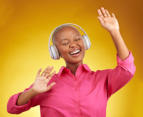 Image showing Happy, music headphones and black woman dance in studio isolated on a yellow background. African person, smile and listen to radio, singing and streaming audio, podcast or hearing sound with energy