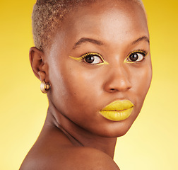 Image showing Beauty, makeup and portrait of a woman in a studio with eyeliner and lipstick for cosmetology. Self care, cosmetic and young African female model with a colorful face routine by a yellow background.