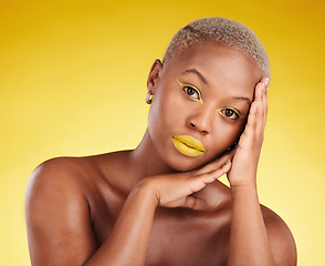 Image showing Cosmetics, glow and african girl in portrait for skincare in yellow studio or gold background for facial. Woman, serious and hand on face with makeup for spa treatment for dermatology or wellness.