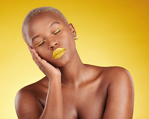 Image showing Creative, makeup and face with lipstick or black woman in studio on a yellow background for art, beauty or cosmetics. Gold, color and eyeshadow on calm model sleeping with unique aesthetic or art