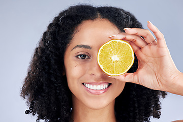 Image showing Skincare, smile and lemon eye for nutrition or fruit with glow in grey studio background. Female person, portrait and vitamin c or natural with facial treatment and organic food for dermatology.