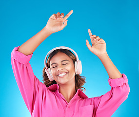 Image showing Woman, student headphones and happy music for audio streaming service or mental health podcast in studio. Young person dance or listening to radio for wellness and excited on a blue background