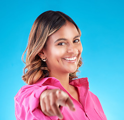 Image showing Pointing finger, smile and portrait of woman in studio to select, advertising or choice. Face of happy model person with hand or emoji for accountability, decision or choosing you on blue background