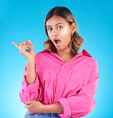 Image showing Surprise, pointing and space with portrait of woman in studio for news, presentation or idea. Wow, shocked and promotion with person on blue background for information, choice and announcement mockup