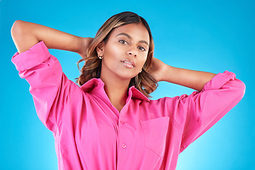 Image showing Woman, confident portrait and fashion in studio for beauty, cosmetics and natural makeup. Young Indian female model person with hands behind head on blue background with casual style clothes and glow