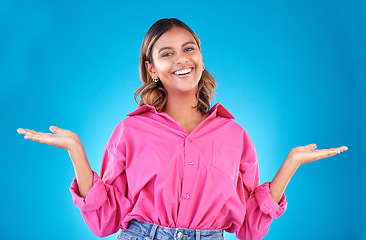 Image showing Space, choice and presentation with portrait of woman in studio for decision, show and information. Offer, advertising and deal with face of person on blue background for thinking, option and mockup