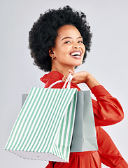 Image showing Shopping bag, happy portrait and woman with fashion discount, sale and retail promotion on a white background. Gift, giveaway and young customer, model or african person with clothes in studio