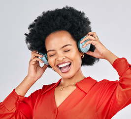 Image showing Excited black woman, music and headphones in studio for podcast subscription on white background. Face of happy female model singing while listening to audio, streaming sound or hearing song on radio