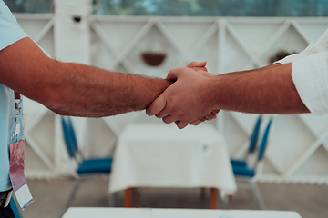 Image showing Close up a handshake, businessman together creates a mutually beneficial business relationship. The economic graph on the table