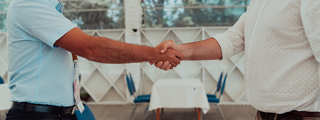 Image showing Close up a handshake, businessman together creates a mutually beneficial business relationship. The economic graph on the table