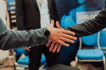 Image showing Close up a handshake, businessman together creates a mutually beneficial business relationship. The economic graph on the table