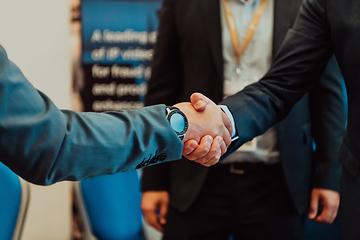 Image showing Close up a handshake, businessman together creates a mutually beneficial business relationship. The economic graph on the table