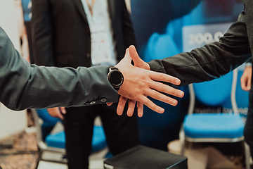 Image showing Close up a handshake, businessman together creates a mutually beneficial business relationship. The economic graph on the table