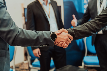 Image showing Close up a handshake, businessman together creates a mutually beneficial business relationship. The economic graph on the table