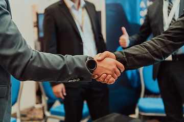 Image showing Close up a handshake, businessman together creates a mutually beneficial business relationship. The economic graph on the table