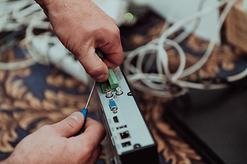 Image showing Repairing a technical device. A repairman repairs a broken device