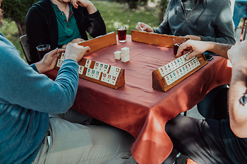 Image showing A group of men drink traditional Turkish tea and play a Turkish game called Okey