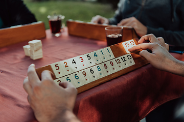 Image showing A group of men drink traditional Turkish tea and play a Turkish game called Okey