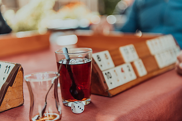 Image showing A group of men drink traditional Turkish tea and play a Turkish game called Okey