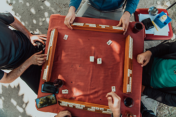 Image showing A group of men drink traditional Turkish tea and play a Turkish game called Okey