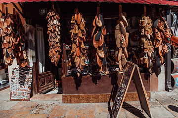 Image showing Macedonian folklore, brown sandals. Old shoes. Part of the tradition. Black pants, close up