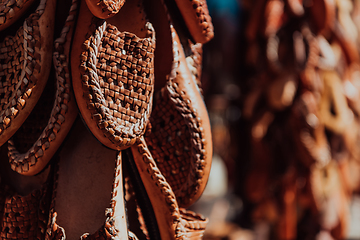 Image showing Macedonian folklore, brown sandals. Old shoes. Part of the tradition. Black pants, close up