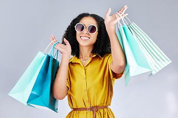 Image showing Sunglasses, portrait and woman with shopping bag for fashion in studio isolated on a white background. Face smile, sales and African customer with gift, discount deal and clothes from retail store