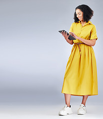 Image showing Tablet, mockup and woman in a studio for online shopping with a sale, deal or promotion. Fashion, happy and full body and young female person with digital technology for ecommerce by gray background.