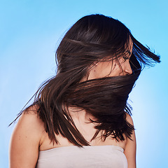 Image showing Woman, shake hair and beauty with growth, shine and self care against a blue studio background. Natural cosmetics, female person or model satisfied with salon treatment, glow and health with wellness