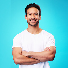 Image showing Smile, confident and portrait of Asian man arms crossed with casual fashion isolated in a studio blue background. Relax, calm and young male person with cheerful or happy mindset and happiness