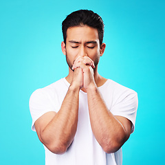 Image showing Man, praying and hands in meditation or worship to God for faith or belief in spirituality, mindfulness and peace in studio. Christian, prayer and person with religion and zen on blue background