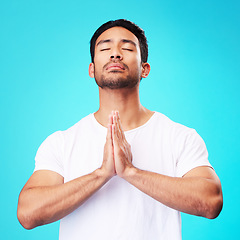 Image showing Meditation, worship or man in prayer with hands and belief or faith in God for spirituality, mindfulness and peace in studio. Christian, praying and person with religion and zen on blue background