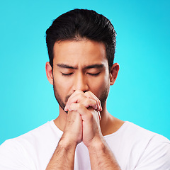 Image showing Praying, hands and man in meditation or worship to God for faith or belief in spirituality, mindfulness and peace in studio. Christian, prayer and person with religion and zen on blue background