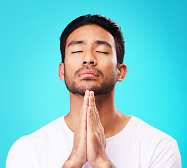 Image showing Praying, man and hands in meditation or worship to God for faith or belief in spirituality, mindfulness and peace in studio. Christian, prayer and person with religion and zen on blue background