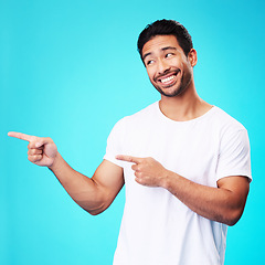 Image showing Mockup, pointing and man with a smile, thinking and choice against a blue studio background. Male person, decision or model with product placement, hand gesture and presentation with sign and showing