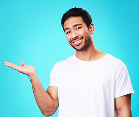 Image showing Gesture, hand and portrait of a man on a blue background for marketing, advertising or a logo. Smile, promo and an Asian person showing mockup space for presentation isolated on a studio backdrop