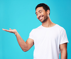 Image showing Mockup, showing and man with a smile, opportunity and decision against a blue studio background. Male person, advertising or model with promotion, hand gesture or presentation with thinking or choice