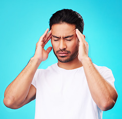 Image showing Stress, pain and man with a headache, burnout and health problem on a blue studio background. Male person, anxiety and model with a migraine, frustrated and tension with strain, fatigue and pressure