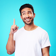 Image showing Mockup, pointing up and man with a smile, thinking and solution against a blue studio background. Male person, decision and model with hand gesture, opportunity or option with sign, choice or showing