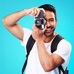 Image showing Portrait, smile and man with a camera, photography and taking picture against a blue studio background. Face, male person or model with creativity, vintage technology or photographer with inspiration