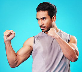 Image showing Fitness, man and fighter training, sports and exercise against a blue studio background. Male person, sweating or serious athlete with power, strong or energy with workout goals, fight or competition