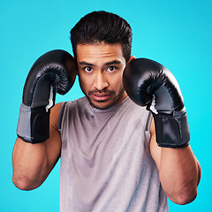 Image showing Boxing, man and fighter training, portrait or challenge against a blue studio background. Male person, boxer or serious athlete with power, face or energy with workout goals, fight or strong champion