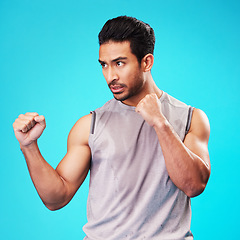 Image showing Fitness, man and fight hands on blue background ,sports and workout goals with a challenge. Male person, studio and serious athlete with power, strong and energy with exercise, fighting and battle